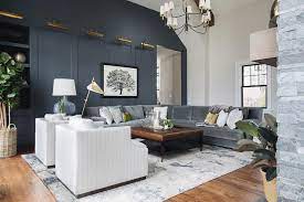 For example, paint a room blue, then mix blue upholstered pieces with white or gray pieces and add touches of yellow, green and orange. Dark Blue Paneled Wall With Antique Brass Picture Lights Transitional Living Room