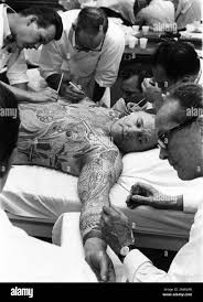 ROD STEIGER with Make Up Artists painting tattoo images to his body  production candid during filming