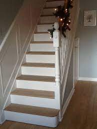 Oak And White Painted Stairs Wrapped Bannister With Lit Pine Christmas Garland White Panelling On The Stairs Painted White Painted Stairs Painted Staircases