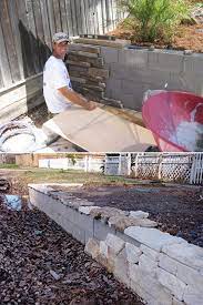 Build A Backyard Retaining Wall With Concrete Blocks And Then Adorn It With Stone Facad Backyard Retaining Walls Diy Retaining Wall Landscaping Retaining Walls