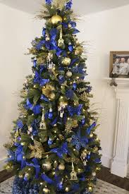 Similarly, the christmas tree adorned with white and silver colored shiny tree ornaments, silver star tree topper, and golden fairy lights add a festive charm to the dining room decorations. Remodelaholic Gold And Blue Dollar Store Christmas Tree Decorating 3 Money Saving Christmas Tree Hacks