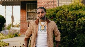 Enter & enjoy it now! Pop Smoke Is Standing In Front Of House Wearing Light Brown Coat And White T Shirt Hd Celebrities Wallpapers Hd Wallpapers Id 36316