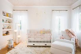A tree and bird wall sticker sets a cute backdrop to the white crib in this nursery showcasing a shaggy area rug and open shelving filled with frames and orange boxes. Beautiful Baby Rooms Nursery Decorating Ideas Hgtv