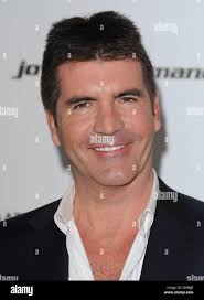 Simon Cowell, television personality, entrepreneur, and record executive,  his partner Lauren Silverman and their son Eric, center, attend the Derby  horse race meeting at Epsom racecourse, near London, England, Saturday,  June 5,