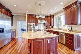 Crafted of poplar solids, cherry veneers and engineered wood. Warm And Inviting Kitchen With Large Kitchen Island Cherrywood Cabinets Sandy Counter Tops And Modern Stainless Steel Refrigerator Northwest Usa Stock Photo Picture And Royalty Free Image Image 70908223
