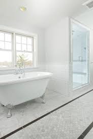 By keeping the walls and the vanity simple and neutral, the designer is able to experiment with the shower and floor tiles and create a load of visual interest with this starburst pattern. Long Bathroom With Carrera Marble Hexagon Tiles And Gray Border Tiles Transitional Bathroom