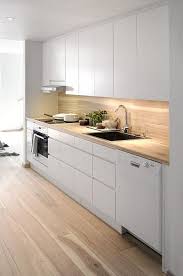 A Minimalist White Kitchen With Sleek Cabinets And A Light Colored Wood Countertop And Backsplash Plus A Kitchen Design Kitchen Design Small Minimalist Kitchen
