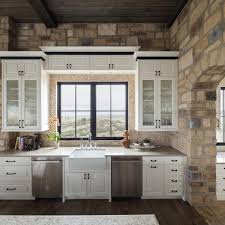 This can also be seen on the kitchen island in the center of the room. Kitchen With Stone Walls White Cabinetry Neutral Tile Backsplash Hgtv