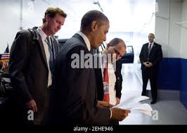 President Barack Obama confers with Trip Director Marvin Nicholson, left,  and Ben Rhodes, Deputy National Security Advisor for Strategic  Communications as they stand by the motorcade prior to a Young African  Leaders Initiative (YALI) town hall in ...