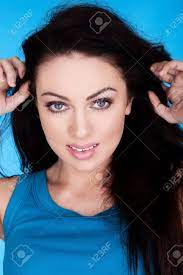 Beautiful Blue Eyed Brunette. Facial Close-up Of A Beautiful Brunette Woman  With Blue Eyes Wearing Blue On A Blue Background. Stock Photo, Picture and  Royalty Free Image. Image 12589758.