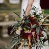 Reserved black feather and rich red rose bouquet and boutonniere set photos are from a previous bride's set. 1