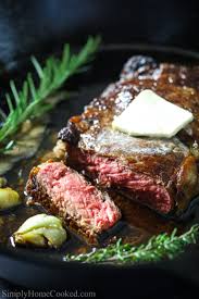 Ribeye Steak Sliced On A Black Platter With Butter Garlic Cloves Thyme And Rosemary Sprigs Ribeye Steak Steak Dinner Ribeye Steak Recipes
