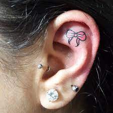 27 Ear Tattoo Ideas That Are Whispering For Your Attention Pink Bow Tattoos Unique Body Piercings Ear Tattoo