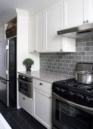 Light Gray Subway Tile Backsplash With Dark Grey Tile Floors And White Cabinets Love This Kitchen Backsplash Designs Kitchen Renovation White Modern Kitchen