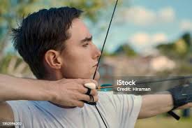 Archer Aiming With Bow And Arrow Stock Photo