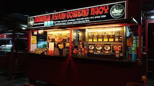 Kamera menyoroti ayam goreng yang terlihat renyah dan empuk saat dicicip sang aktor. Burger Ayam Goreng Njoy Penang Malaysia Travelopy