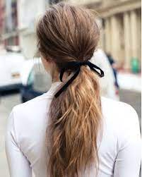 Updos For Thin Hair Back View Close Up Of A Woman With Long Brown Hair In A Tousled Low Ponytail With A Black Ribbon B Hair Styles Simple Ponytails Hair Looks