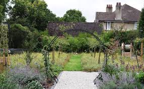 This Trellis Moon Gate Frames A Mown Edge Wild Flower And Fruit Tree Planting Garden Design Trees To Plant Garden Arch