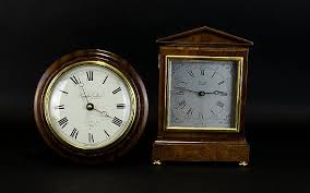 Schatz, the original 400 day clock. Lot Two Modern Quartz Clocks Comprising Of Comitti Of London Mantel Clock With White Chapter Dial And Roman Numerals 9 Inches In Height Together With Knight Gibbins Circular Wall Clock 8