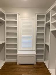 The details in this closet are what make the space, the trim work, built in window seat, and don't forget the lighted wardrobe with glass front doors! Custom Closets Raleigh Durham Chapel Hill Wake Forest Woodmaster Custom Cabinets