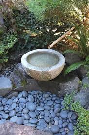 This japanese inspired garden features a pond filled with lilies and concrete footsteps where guests can cross to the other side of the garden. 56 Japanese Water Feature Ideas In 2021 Japanese Garden Japanese Water Feature Zen Garden