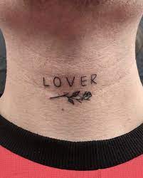 A Word Lover Is Inked In The Minimalist And Small Font On The Front Of The Neck Together With A Tiny Rose Small Neck Tattoos Tattoos For Lovers Lover Tattoo