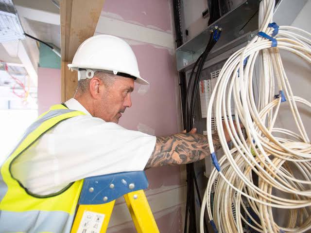 Electrician tightening connections on a consumer unit in Welling