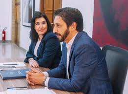 Simone Tebet e Renan Calheiros em reunião. Mulher de cabelo escuro e homem de barba sentados à mesa.