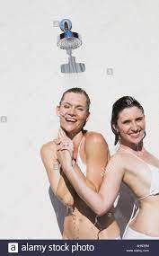 Lesbian couple showering by swimming pool Stock Photo - Alamy