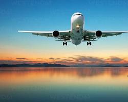 Image of airplane flying over a sunset