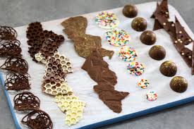 Pipe circle swirls of chocolate over one end and sprinkle with hundreds and thousands. 7 Chocolate Decorations Perfect For Cupcakes