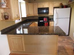 Dark cherry cabinets, uba tuba granite countertops, and neutral colored floor and wall tile. Kitchen Gallery Pg2