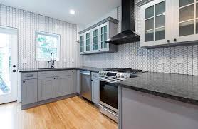 A minimalist grey kitchen with a small wood hexagon tile backsplash over the cooker is a stylish idea; Subway Tile Kitchen Backsplash Ultimate Guide Designing Idea