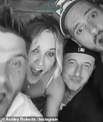 Ashley Roberts, 43, turns heads in a glitzy gold mini dress as she plants a  kiss