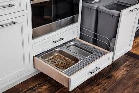 White Kitchen Cabinets Adorning Polished Nickel Pulls Are Fitted With A Pull Out Dog Food And Water Draw Food Storage Cabinet Dog Food Recipes Dog Food Cabinet