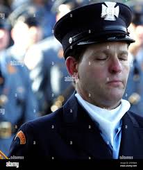 New Jersey Color Guard, John Ripnick closes his eyes as the casket of  Jersey City police officer Robert Nguyen goes by during funeral services at  the Jersey City Armory in Jersey City,