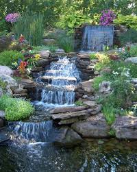 The water naturally tumbles over the rocks and has natural plantings on both sides. Beautiful Backyard Waterfall Ideas Waterfalls Backyard Waterfall Landscaping Water Features In The Garden