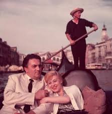 italian film director federico fellini and his wife actor giulietta masina hold hands and smile while sitting in a gondola wit film film director film images
