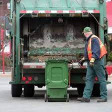 Waste Management Worker Prepares To Unload Green Bin Into Truck Waste Removal Trash Waste