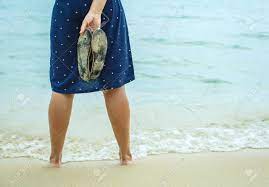 Woman Standing On The Beach And Holding In His Hand Spanking Stock Photo,  Picture and Royalty Free Image. Image 47983338.