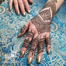 Flowers And Various Florishes In Dark Borwn Drawn On A Hand With Gold Nail Polish Henna Tattoo On The Hand Fingers And Wris In 2020 Cute Henna Designs Cute Henna Henna