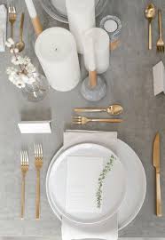 A Minimalist Wedding Table Setting With A Grey Tablecloth Gold Cutlery And White Candles Looks Ethe Grey Tablecloths Modern Table Setting White Table Settings