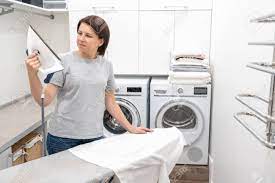 Looking for laundry service that will actually care about your clothes? Woman Looking With Surprise At Bottom Of Iron In Laundry Room Stock Photo Picture And Royalty Free Image Image 134957788