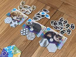 Game board colored tokens, each representing a suspect : Calico Board Game Review Nerdly