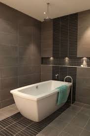 Rain Shower Over A Deep Freestanding Bath Gorgeous Integrated Floor To Ceiling Tiling Bathroom Tile Designs Tile Bathroom Free Standing Bath Tub