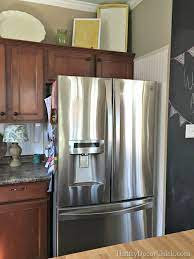 Once your refrigerator is in place, you can start building the cabinet around it. Building In A Fridge With Cabinet On Top From Thrifty Decor Chick