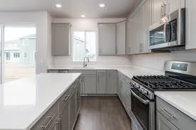 white quartz countertops and on trend gray cabinetry give this open kitchen a modern chic feel new homes for sale new home construction kitchen design
