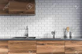 These wall kitchen ideas using white wood panels to bringing that clean and pure feeling. Modern Kitchen Interior With White Brick Walls Dark Wooden Countertops Stock Photo Picture And Royalty Free Image Image 98027099