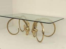 Round brass coffee table with glass top, four ram's head accents, and hoof feet. Polished Brass Ibex Or Ram S Head Coffee Table For Sale At 1stdibs