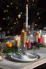 prachtige decoratie op een houten tafel op de tafel staan kleurrijke kaarsen met een dennenboom en wat groen met dez kerstdiner tafels kaarsen kerstdecoratie